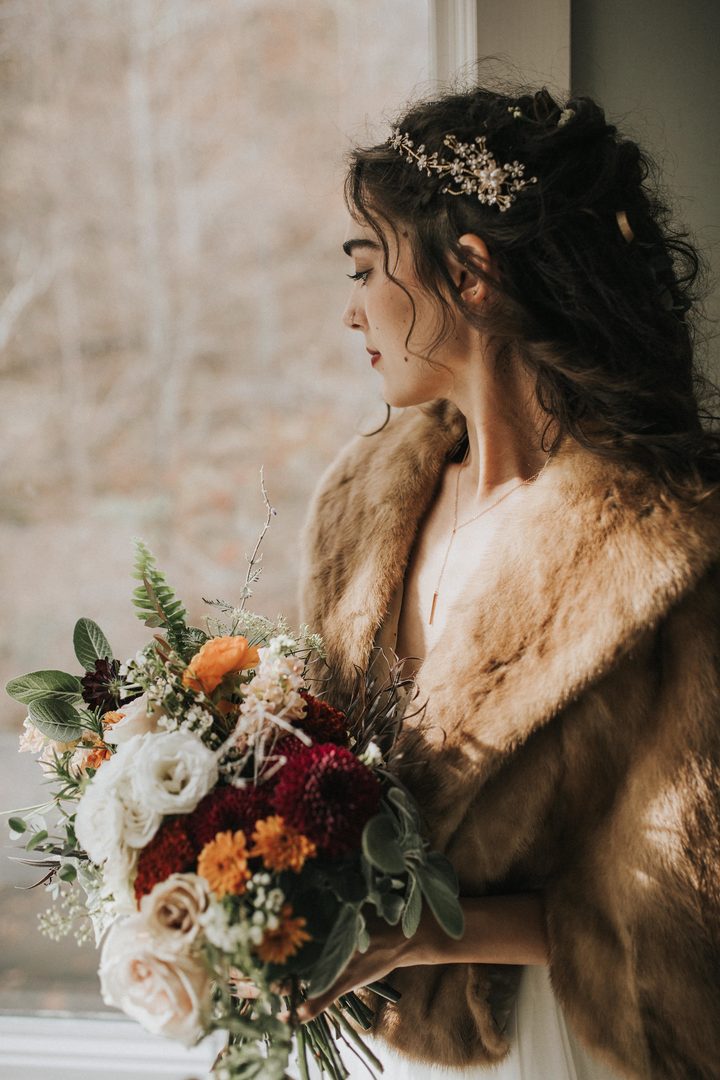 Bride in a fur wrap with a loose autumn bouquet